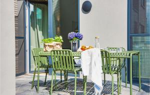 a table and chairs on a patio with flowers at Nice Home In Lembruchdümmer See in Lembruch