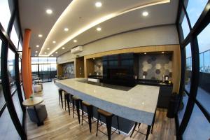 a kitchen with a large island in a room with windows at Ap no coração de POA in Porto Alegre