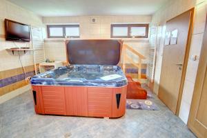 a jacuzzi tub in the middle of a room at Wellness Chata Kastanek in Kvilda