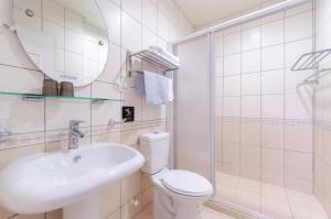 a bathroom with a toilet and a sink and a mirror at Happy Fun 樂放晴民宿 in Jian