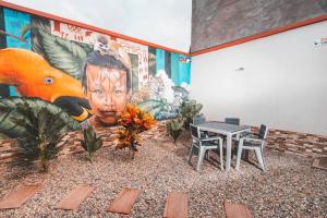 una mesa y sillas en una habitación con un mural en Casa Guaviare, La Mejor Opción Para Ti, en San José del Guaviare