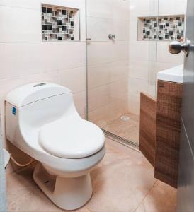 a bathroom with a white toilet and a shower at Casa Guaviare, La Mejor Opción Para Ti in San José del Guaviare