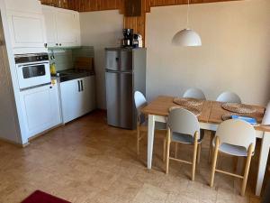 uma cozinha com uma mesa e cadeiras e um frigorífico em Peaceful holiday apartment with stunning lake view em Joutsa