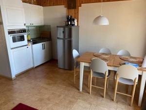 a kitchen with a table and chairs and a refrigerator at Peaceful holiday apartment with stunning lake view in Joutsa