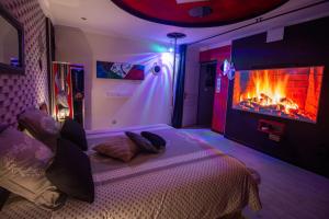 ein Schlafzimmer mit einem Bett und einem Kamin in der Unterkunft O LOFT in Audincourt