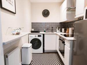 Una cocina blanca con lavadora y secadora. en PER7-FM · Nice 1 Bed Ground Floor Flat, near Cessnock Subway, en Glasgow