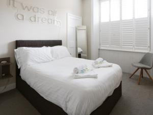 a bedroom with a bed with towels and a chair at PER7-FM · Nice 1 Bed Ground Floor Flat, near Cessnock Subway in Glasgow
