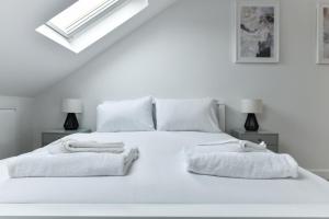 una camera bianca con un letto bianco e asciugamani di Claude House - charming 4Bedroom Home a Nottingham