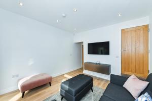 een woonkamer met een bank en een tv bij Claude House - charming 4Bedroom Home in Nottingham