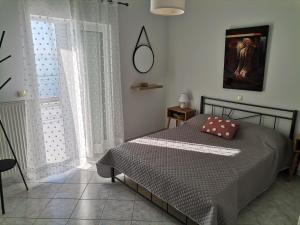 ein Schlafzimmer mit einem Bett und einem großen Fenster in der Unterkunft Διαμέρισμα Παραλία Μενιδίου in Menídion