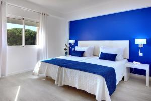 a blue bedroom with a large bed with a blue wall at Zodiaco in Quarteira