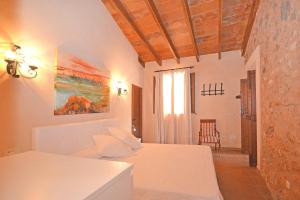 um quarto com uma cama branca e um quarto com uma janela em Villa Alba em Llubí