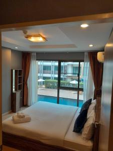 a large bed in a room with a large window at ไอยรา อยุธยา The Aiyara Ayutthaya in Phra Nakhon Si Ayutthaya
