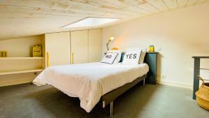 a bedroom with a bed with two pillows on it at Charmante villa dans le centre du village in Le Bois-Plage-en-Ré