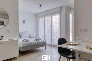 a bedroom with a bed and a table and a dining room at Le Season - Bel appartement - Proche Disney & Paris RER E in Villiers-sur-Marne