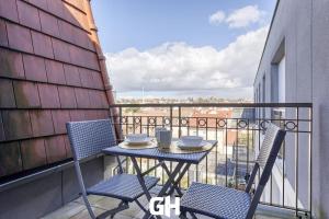 una mesa y sillas en un balcón con vistas en Le Season - Bel appartement - Proche Disney & Paris RER E en Villiers-sur-Marne
