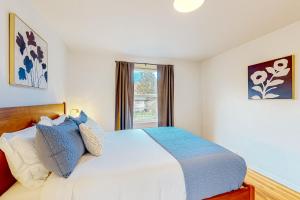 1 dormitorio con cama blanca y ventana en Charming Bryant Bungalow, en Seattle