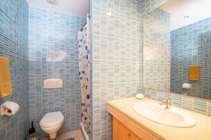 baño de azulejos azules con lavabo y aseo en Apartamento Corcovada by Umbral, en Albufeira