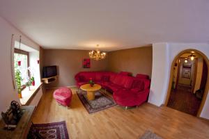 ein Wohnzimmer mit einem roten Sofa und einem Tisch in der Unterkunft Sonnenhäusle Klaus und Sabine Schmid in Immenstadt im Allgäu