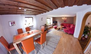 ein Wohnzimmer mit einem Tisch und einem roten Sofa in der Unterkunft Sonnenhäusle Klaus und Sabine Schmid in Immenstadt im Allgäu