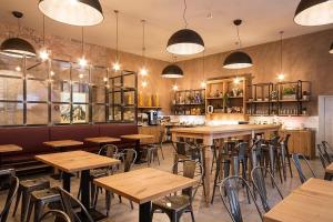 a restaurant with wooden tables and chairs and lights at Hotel & Hostel 7 in Florence