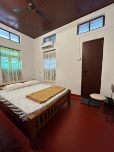 a bedroom with a bed and a ceiling fan at Lannister Inn in Cochin