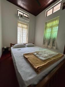 a large bed in a room with two windows at Lannister Inn in Cochin