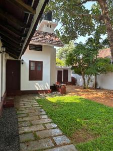 a small white house with a tower on top of it at Lannister Inn in Cochin