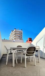 a table and chairs on a balcony with a building at Atico a dos minutos de la playa in Fuengirola