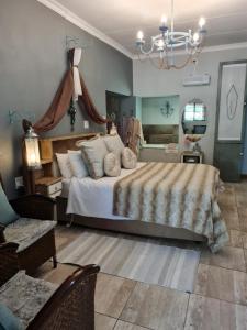 Un dormitorio con una cama grande y una lámpara de araña. en Little Rock Resort en Ladybrand
