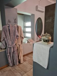 a bathroom with a towel on a rack and a mirror at Little Rock Resort in Ladybrand