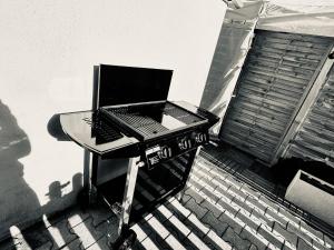 Telewizja i/lub zestaw kina domowego w obiekcie Résidence CAENEE, le dépaysement Naturiste en été avec l'atypique studio climatisé "vintage" en sous pente, sa "paillote" avec jacuzzi, entouré de verdure, planchagrill, transats, vélos gratuits, wifi 5G, Travel Proud LGBTQI, chiens admis