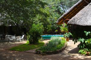 a resort with a pool and a table and chairs at Mawuya Lodge in Victoria Falls