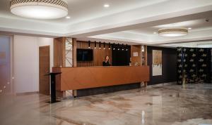 a woman is standing in the lobby of a building at Hotel Ariata in Scheia