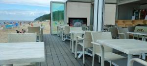 a row of tables and chairs on the beach at Villa Martini in Międzyzdroje