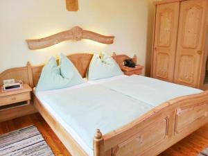 - duże drewniane łóżko z niebieskimi poduszkami w pokoju w obiekcie Gasthof Dürregger w mieście Leiben