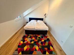 オッフェンバッハにあるApartment Lili-PS5-Terrace-View-Bright-Kitchen-2xBedroomのベッドルーム1室(カラフルなラグのベッド1台付)
