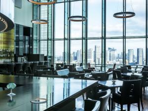 a restaurant with tables and chairs and a large window at The Royal Park Hotel Iconic Tokyo Shiodome in Tokyo