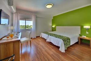 a green bedroom with a bed and a table and a desk at Zodiaco in Quarteira