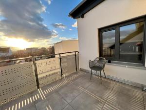 einen Balkon mit einem Stuhl und Stadtblick in der Unterkunft Apartment Lili-PS5-Terrace-View-Bright-Kitchen-2xBedroom in Offenbach