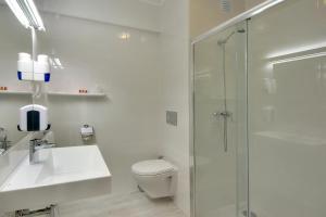 a bathroom with a toilet and a sink and a shower at Zodiaco in Quarteira +25 photos