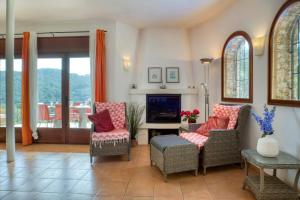 a living room with chairs and a fireplace at Begur - Sa Riera 152 in Begur