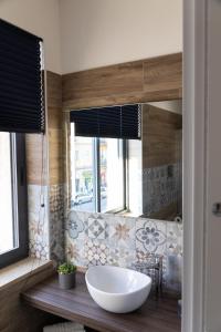 bagno con grande lavandino bianco e specchio di Famalu apartments a Napoli