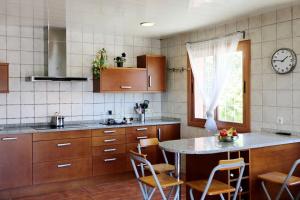 a kitchen with a table and chairs and a clock at CAL XECARMA in Tordera