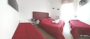レッチェにあるLa Dimora dei Professori DiffusHotelの赤いシーツが備わるベッドルームのベッド2台