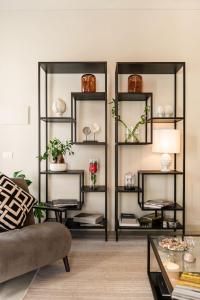 a living room with black shelves with plants at Casa San Lio in Noto
