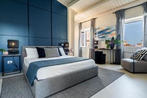 a bedroom with blue walls and a bed and a chair at Casa San Lio in Noto +47 photos