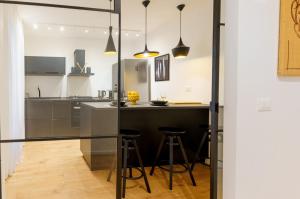 kuchnia z blatem i barem ze stołkami w obiekcie Parlamento Apartment - Esclusivo 120mq centro storico Palermo w mieście Palermo
