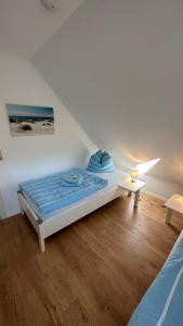 a bedroom with a bed and a table on a wooden floor at Ferienwohnung "Am Walde" in Lubmin