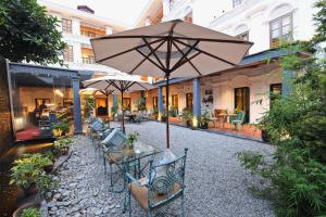 a patio with tables and chairs and an umbrella at Seto Ghar Hotel in Kathmandu